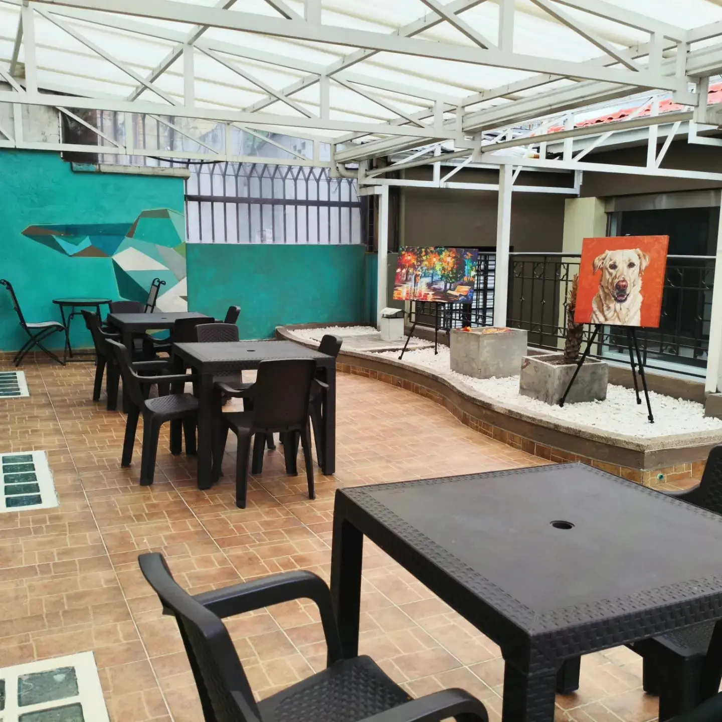 Terraza amplia con arte y mesas en Casa Veka