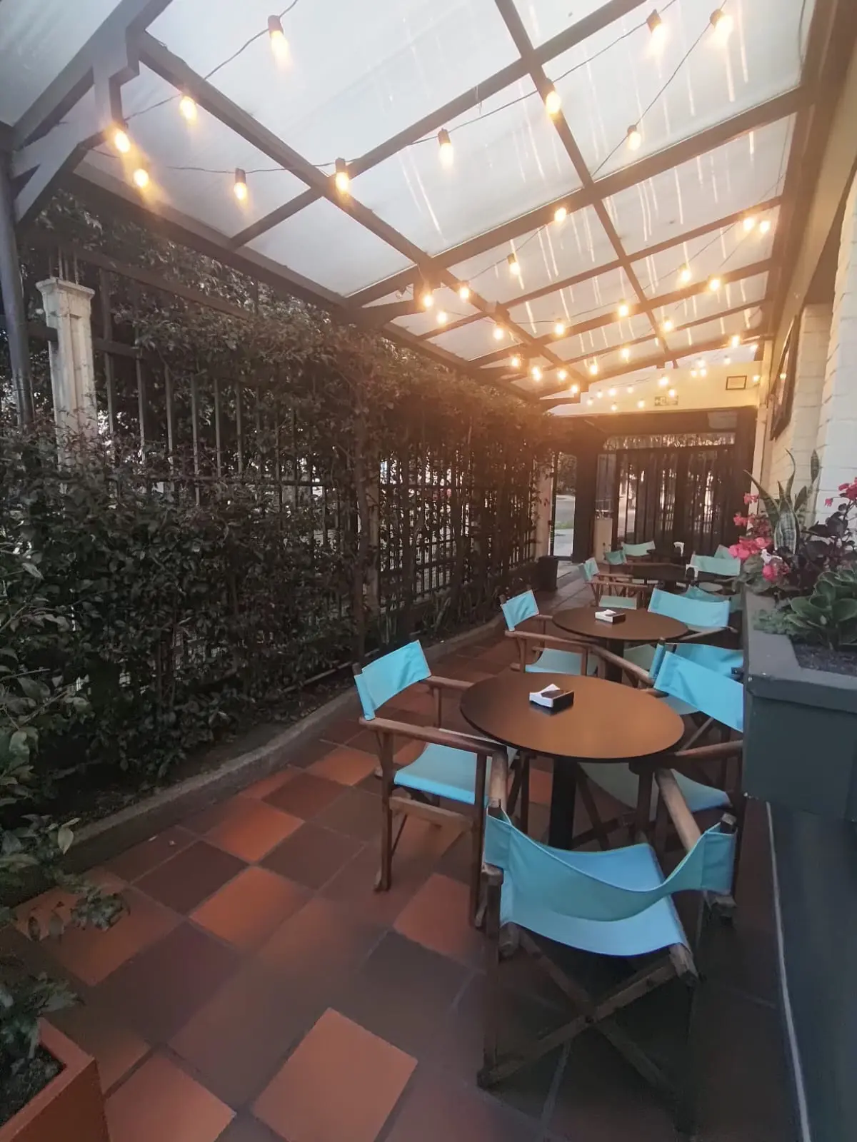 Terraza cubierta con mesas y luces cálidas
